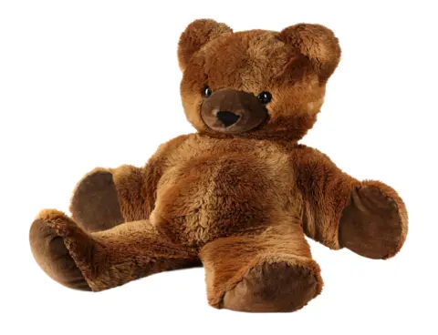 Propstore A stuffed brown bear sitting against a white background