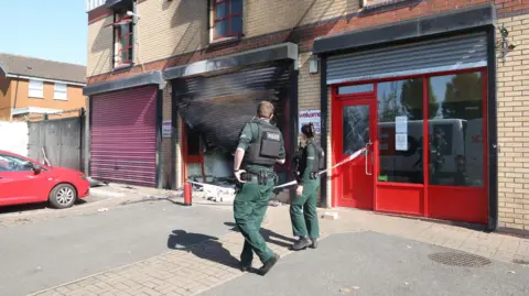 Police at the scene of the attack on the Welcome Organisation