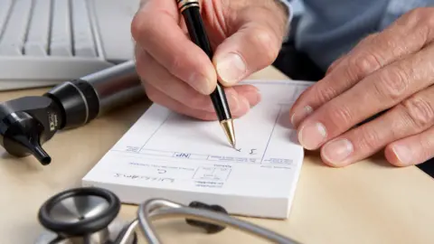 Getty Images Doctor writing a prescription