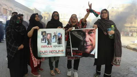 Imran Khan's supporters shout slogans as they block a road during a protest against the arrest of their leader in Hyderabad