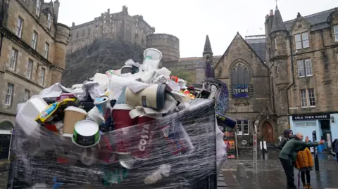 PA Media An overflowing bin in the Grassmarket