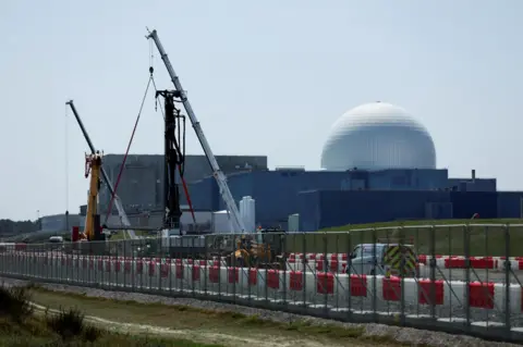 Reuters Cranes operating on the Sizewell C build site, with the Sizewell B and A nuclear power stations in the background.