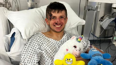 Corey Russell, 19, smiling, in a hospital gown