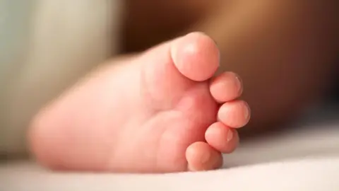 Getty Images Close-up representation  of a newborn baby's foot