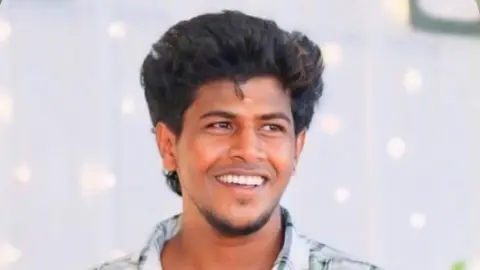 A photo of a smiling Akash looking away from the camera