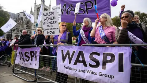 Getty Images A Women Against State Pension Inequality [Waspi] demonstration. A group of women are stood behind metal fencing which has WASPI banners on it with the words 'Salisbury and Wilts Group' on them. Some of the women are blowing whistles, some are holding banners. Some are also wearing sashes. They are protesting outside of Parliament. 