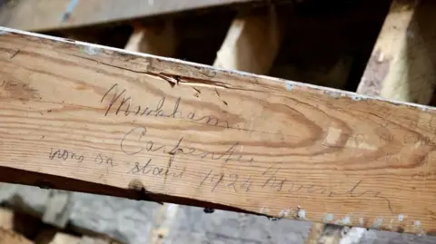 Doddington Hall A floorboard, with a man's signature, is shown close up 