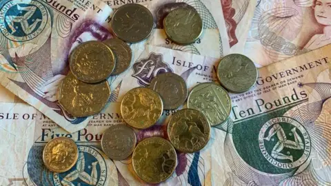 BBC Manx pound coins on Manx five, ten and twenty pound notes.