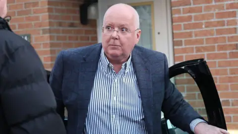 Peter Murrell climbing out of a car
