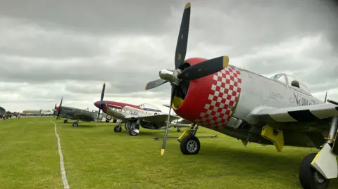 Emma Baugh/BBC World War Two aircraft lined up on the grass at an overcast Imperial War Museum, Duxford