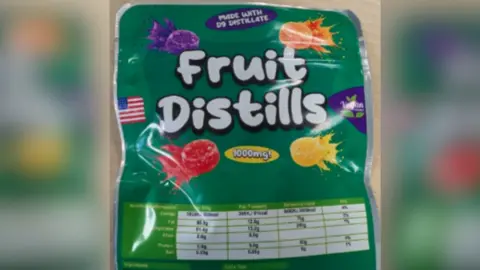 A green bag which says 'Fruit Distills', with '1000mg' written in a yellow bubble and images of sweets. It looks similar to a packet of Fruit Pastilles.