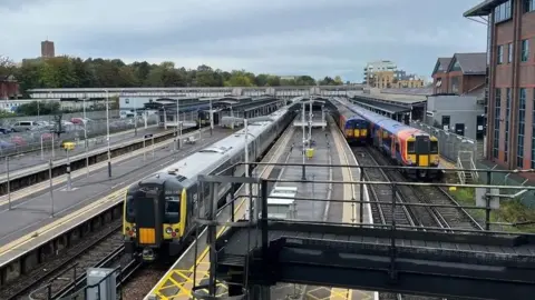 Three trains approaching a train station.