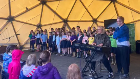 Pupils on stage with H and Caryl Parry Jones