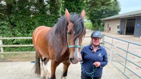 BBC Sarah Hollister standing next to a horse