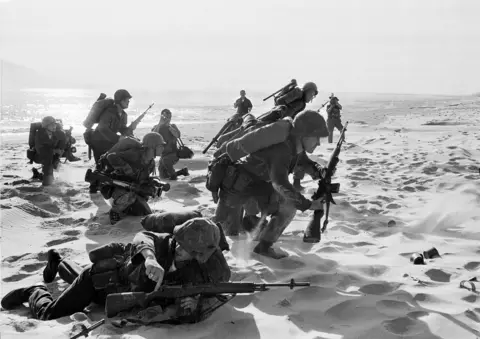 AP Photo/Peter Arnett/File Newly-landed U.S. Marines make their way through the sands of Red Beach at Da Nang, Vietnam, on their way to reinforce the air base as South Vietnamese Rangers battled guerrillas several miles south of the beach, April 10, 1965.
