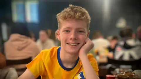 Supplied Max, smiling at the camera, wearing an earlier design of Mansfield Town shirt