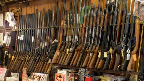 A line of shotguns and rifles on display at a US gunstore 