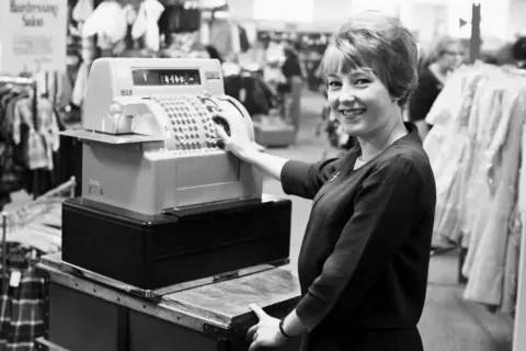 Woman looking pleased with a till