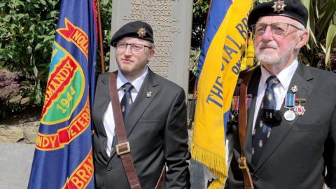 Two men holding Royal British Legion standards 