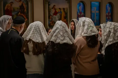 Members of the Syrian orthodox congregation singing hymns at a memorial service in Orebro.