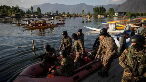 Reuters Indian security force personnel patrol in a boat in the waters of Dal Lake as tourists ride "Shikaras" or boats, following a suspected militant attack near south Kashmir's Pahalgam, in Srinagar April 25, 2025. REUTERS/Adnan Abidi