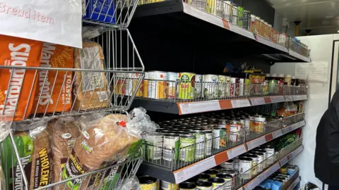 Shelves of tinned food inside the mobile pantry