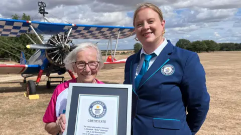 Two women are standing next to each other holding a certificate from Guinness World Records.