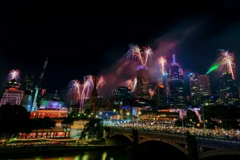 Asanka Ratnayake / Getty Images Uma visão geral dos fogos de artifício e show de luzes de ano novo voltados para o distrito comercial central em 1º de janeiro de 2025 em Melbourne, Austrália. 