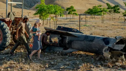 Israeli settlers use a tractor to haul away a large section of a downed Iranian missile toward their farm on June 8, 2026 on the outskirts of Jericho, Israel.