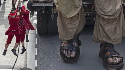 PA Puppeteers lift in the air as they try to manouevre the puppet