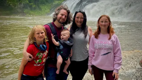 Chris Mathews The Matthews family stand in front of a waterfall