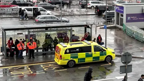 An emergency vehicle outside Heathrow Terminal 3 after a man has been arrested on suspicion of assault after number of people were attacked with "a form of pepper spray" by a group of men at a car park at Heathrow Airport, police said. Picture date: Sunday December 7, 2025.