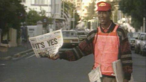 Man holding newspaper showing South African election result