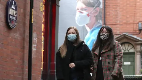 PA Media Two women in face coverings in Manchester