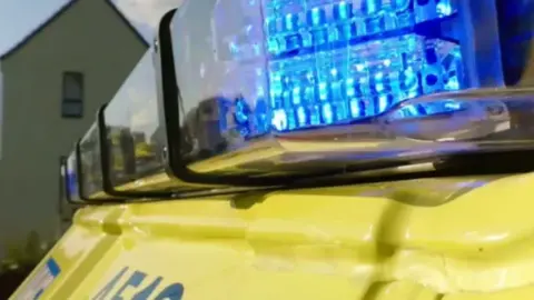 A zoomed in picture of blue lights on a yellow ambulance