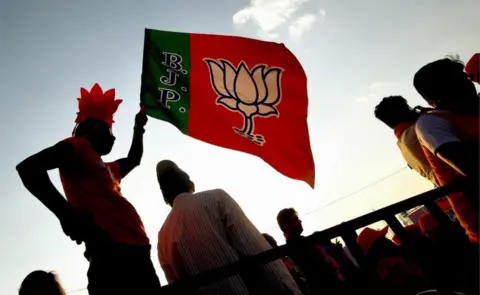 EPA A supporters waves the party flag, during the Bharatiya Janata Party (BJP) election rally meeting in Bangalore, India, 13 April 2019