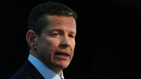 PA Media Rhun ap Iorwerth speaking in front of a black backdrop.