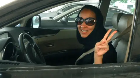 MARWAN NAAMANI/AFP/Getty Images Saudi activist Manal Al Sharif flashes the sign for victory in her car on October 22, 2013