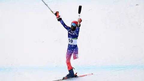Haitian skier Ralf Etienne celebrates at the Winter Paralympics