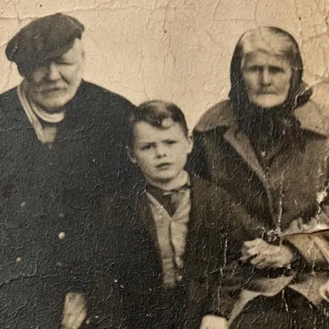 Martha Stewart An old cracked photograph of an elderly couple and a young boy.