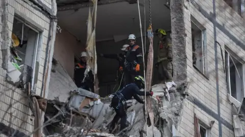 Reuters Rescuers work at the site of the apartment buildings hit during the Russian drone strike, amid Russia's attack on Ukraine, in Dnipro, Ukraine November 8, 2025. 