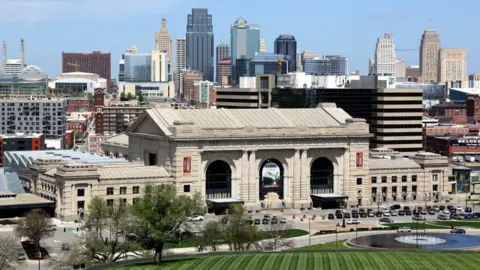 Getty Images Kansas City skyline with striped green lawn in foreground, the historical Union Station behind that and skyscrapers in the far background