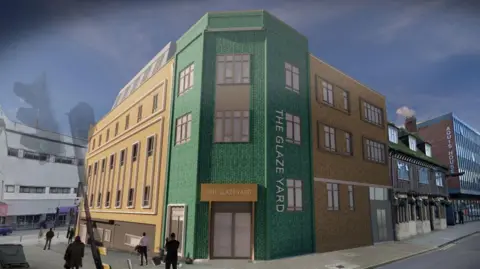 JSO Holdings An artist's impression of a green and sandy coloured building with the words "The Glaze Yard" in large lettering. The building features several small windows and two large main doors.
