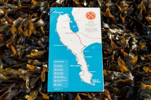 Scottish Power A map of the Rhins of Galloway - a double-headed peninsula - in white on a blue background lying on a bed of seaweed