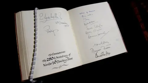 Visitors to the 250th anniversary of Number 10 Downing Street sign including Queen Elizabeth II, Prince Philip and six Prime Ministers, 04.12.1985.