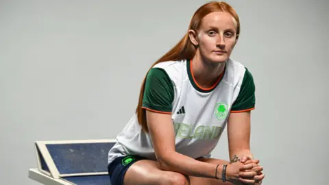 Getty Images A red headed woman sitting down wearing a green white and orange Team Ireland Olympic kit