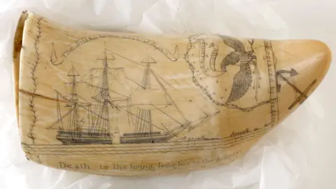 Hull Maritime Museum A large whale tooth has been turned into an artwork depicting a three-masted sailing ship and an eagle. An inscription reads: "The Susan on the coast of Japan". Another reads: "Death to the living, long life to the killers."