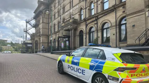 A police car parked outside the Great Victoria hotel in Bradford