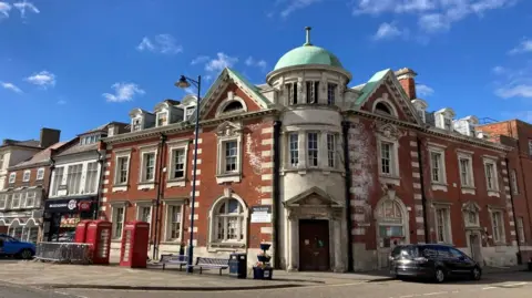 Former Post Office building in Boston town centre. The Grade II listed building has ornate window surrounds and a green domed roof over the entrance.