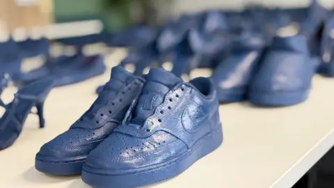 Pairs of shoes - including trainers and high heels - have been painted blue. 